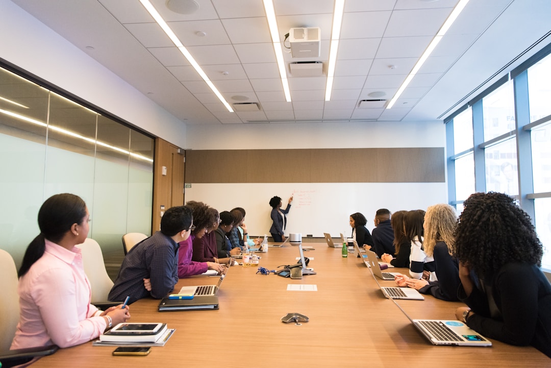 A woman on a whiteboard is explaining to her colleagues the importance of sales bookings in revenue forecasting and business growth