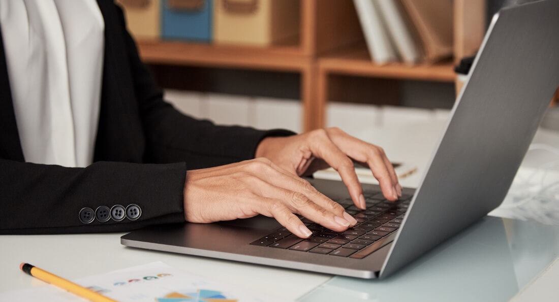 An individual using a laptop to research 'What is a federated search?' and to understand the mechanics behind federated search technology